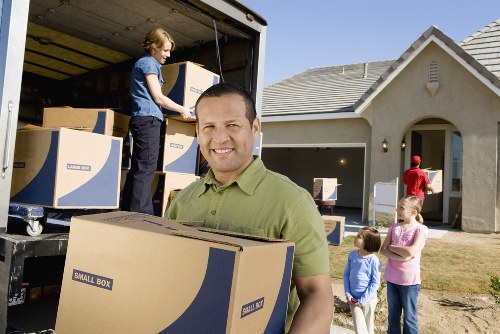 Professional movers handling boxes in a modern Elephant and Castle building